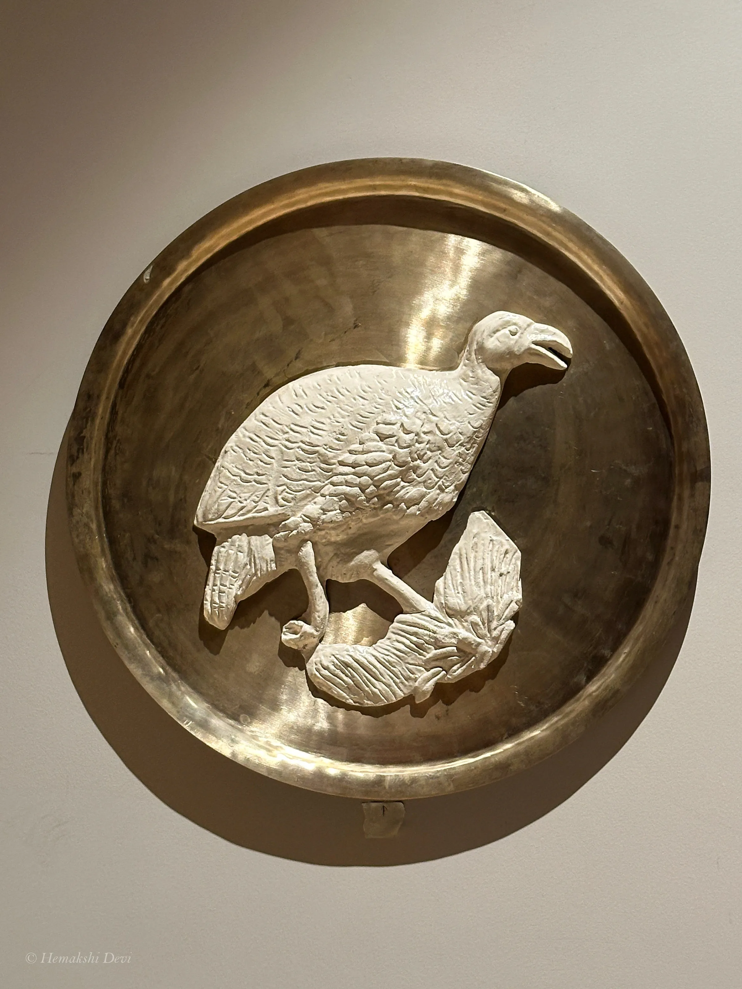 Detail of a bell-metal medallion with a Kaziranga bird relief